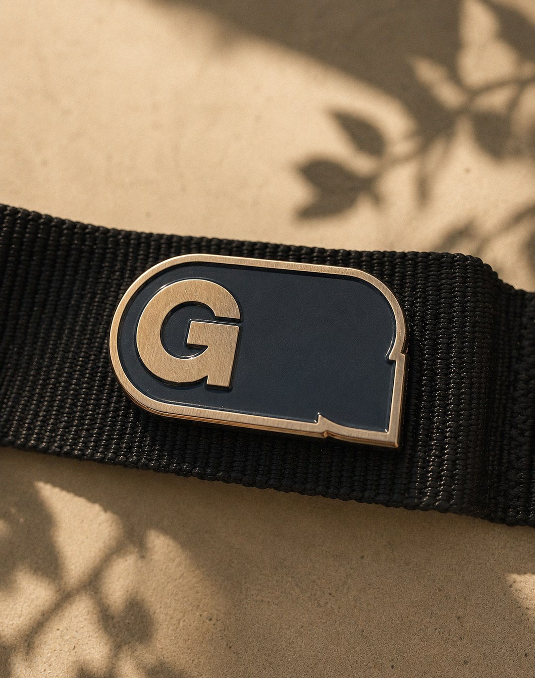 Gentle Rebel G enamel pin on a webbing strap