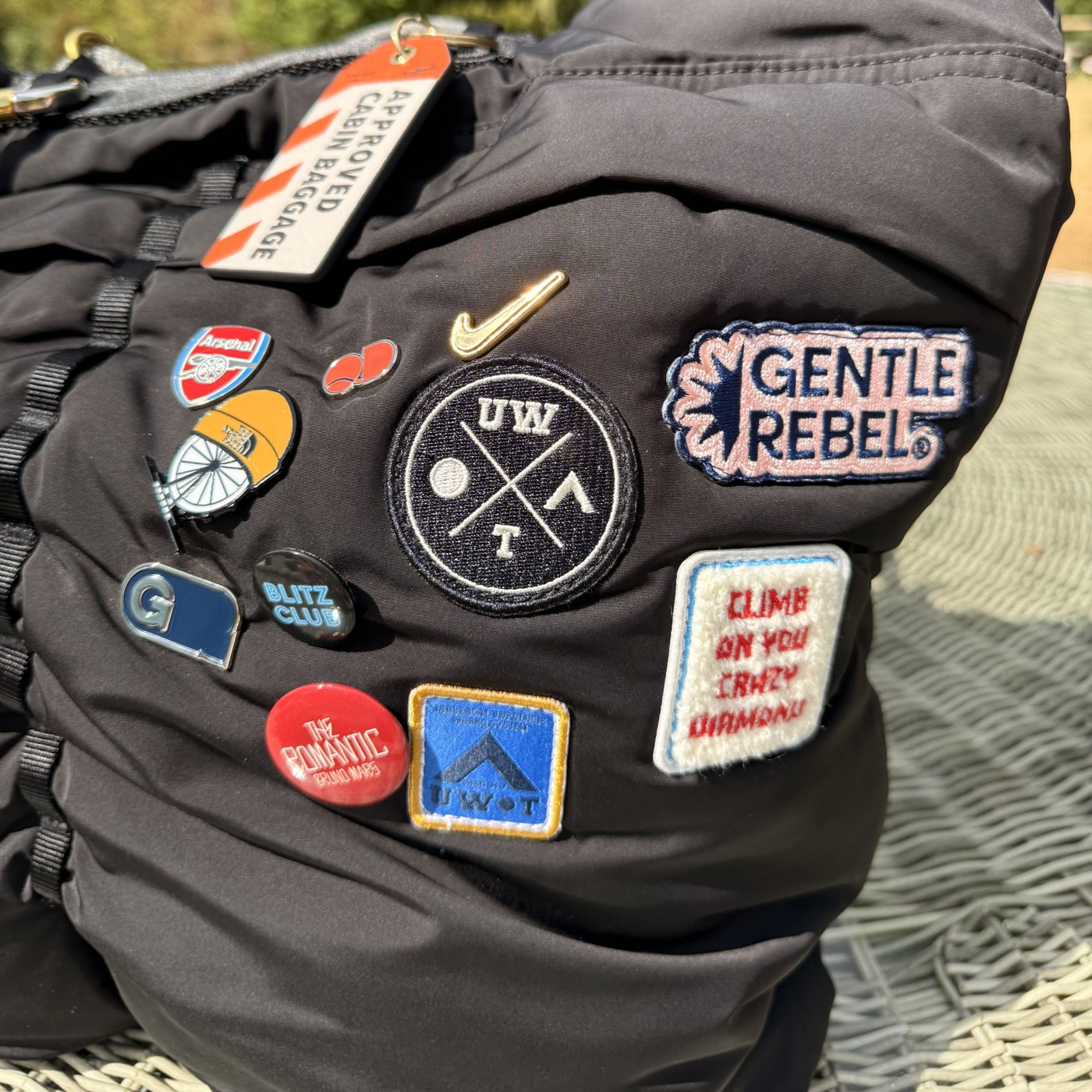 Gentle Rebel patch worn alongside a well-travelled collection of pins and patches