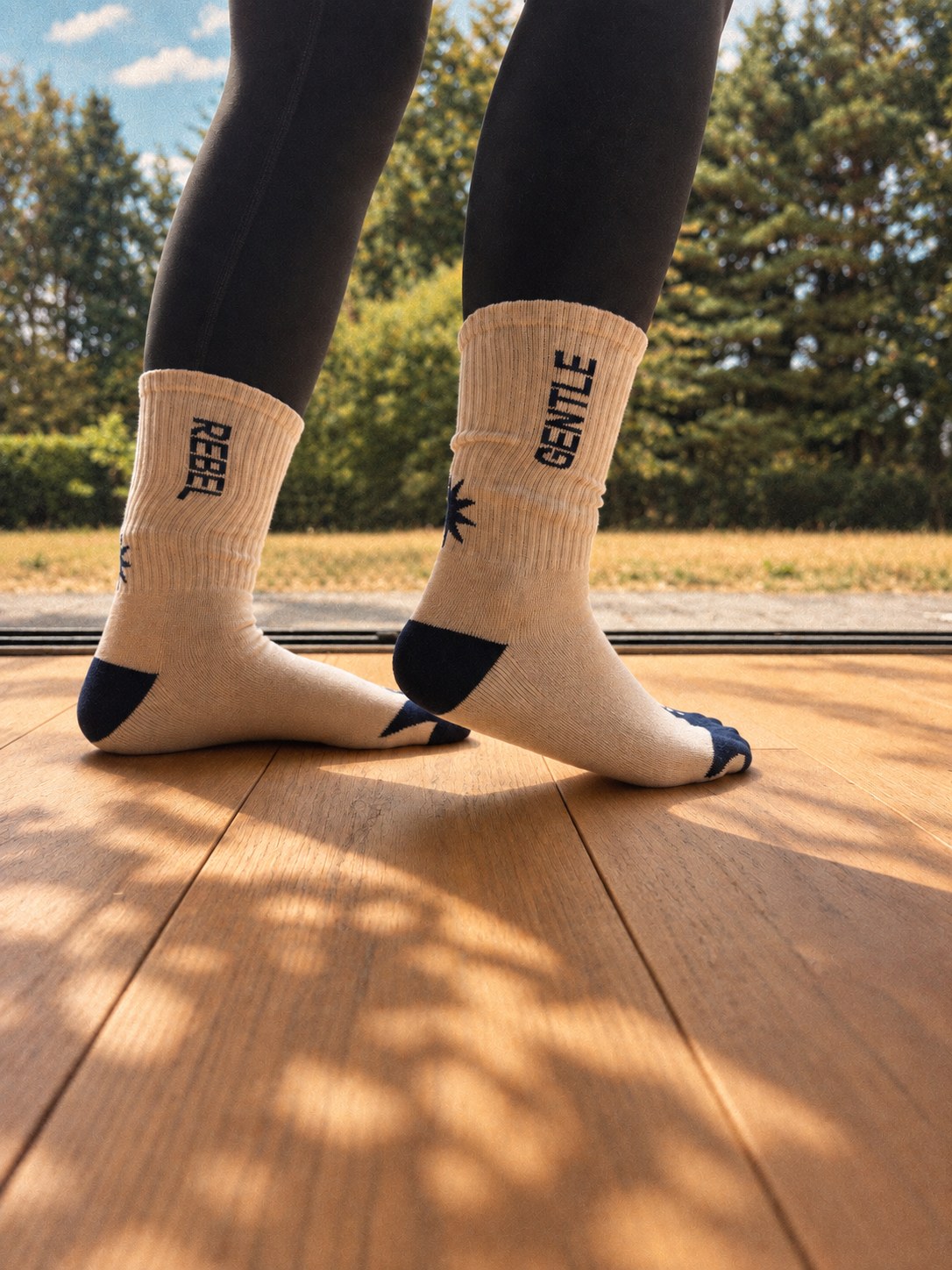Gentle Rebel crew socks in cream and navy, worn outdoors
